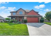 Charming two-story brick home featuring an attached two-car garage and a well-manicured front yard at 8619 Wrangler Ct, Indianapolis, IN 46217