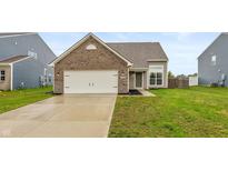 Charming single-Gathering home featuring a brick facade, attached garage, and lush green lawn at 929 Capricorn Dr, Franklin, IN 46131