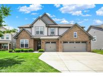 Charming two-story home featuring a brick facade, three-car garage, manicured lawn and beautiful curb appeal at 9716 Cimmaron Ave, McCordsville, IN 46055