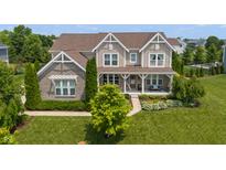 Charming two-story home with a well-manicured lawn, beautiful landscaping, and inviting front porch at 1102 Clearwell Dr, Greenwood, IN 46143