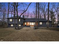 Twilight image of a charming two story home with updated features, landscaping and mature trees at 11035 W Lakeshore Dr, Carmel, IN 46033