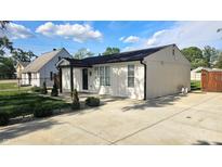 Renovated single story home boasting a modern design, landscaping, and a newly poured concrete driveway at 1125 S Drexel Ave, Indianapolis, IN 46203