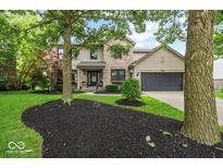Charming two-story home with a brick and vinyl exterior, black mulch beds, and well-manicured lawn at 11987 Quarry Ct, Fishers, IN 46037