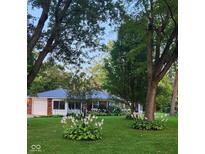Charming brick home with well-manicured lawn and landscaping, featuring a detached garage and mature trees at 1322 Greenway Dr, Anderson, IN 46011