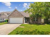 Charming single-Gathering home boasts a brick facade, attached garage, and a well-maintained front yard at 14911 Silver Thorne Way, Carmel, IN 46033