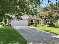 Charming stone and siding home with a well-manicured lawn, long driveway, and mature trees at 177 Wellington Pkwy, Noblesville, IN 46060