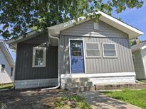 Charming home featuring gray siding, a blue front door, and a well-manicured lawn at 2035 S Pennsylvania St, Indianapolis, IN 46225