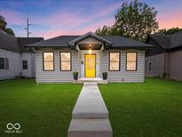 Charming home featuring a bright yellow door, well-maintained lawn, and inviting walkway at 31 Mckenzie St, Shelbyville, IN 46176