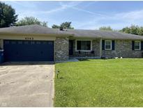 Charming single-story home with a brick facade, blue garage door, and well-manicured lawn at 4343 W Fairview Rd, Greenwood, IN 46142
