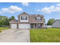 Charming two-story brick home with a three-car garage and well-manicured lawn at 5030 E 800 N, Columbus, IN 47203