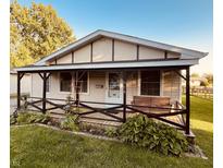 Charming single-story home featuring a quaint covered front porch with a delightful swing and tasteful landscaping at 514 W 6Th St, Sheridan, IN 46069