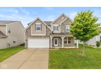 Charming two-story home with stone accents, well-manicured lawn, and an attached two-car garage at 5767 Bluff View Ln, Whitestown, IN 46075