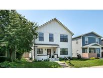 Charming two-story home featuring white siding, a welcoming front porch, and well-maintained landscaping at 615 Orange St, Indianapolis, IN 46203