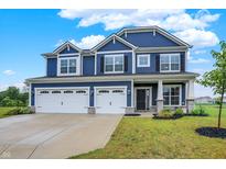 Beautiful two-story blue home featuring a three car garage and manicured lawn on a sunny day at 6762 Brentwood Ct, Brownsburg, IN 46112