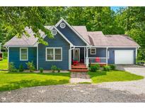 Charming blue home with a welcoming front porch and well-maintained landscaping in a wooded location at 6933 Grey Wolf Dr, , IN 46164