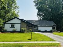 Charming home featuring a well-maintained lawn, contrasted by dark trim against light siding and stone accents at 723 Bennett Rd, Carmel, IN 46032