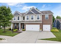 Charming two-story home featuring brick and siding, a well-manicured lawn, and a two-car garage at 7249 Red Maple Dr, Zionsville, IN 46077