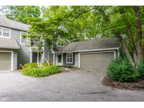 Charming home exterior featuring a lush, tree-lined yard and attached garage at 7803 Harbour, Indianapolis, IN 46240