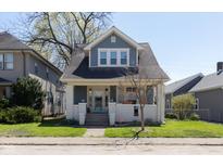 Charming blue two-story home with inviting front porch and well-maintained lawn at 831 Weghorst St, Indianapolis, IN 46203