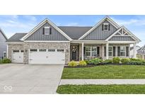 Charming exterior of a stone and gray home with a well-manicured lawn at 1107 Mccray Ln, Westfield, IN 46074