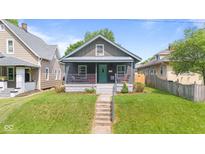 Charming home with a front porch and well-maintained lawn and inviting curb appeal at 1205 N Temple Ave, Indianapolis, IN 46201