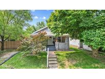 Charming home featuring a welcoming front porch with lovely landscaping and mature trees at 2433 E 16Th St, Indianapolis, IN 46201