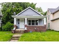 Charming bungalow with a brick-accented porch and fresh gray siding and new landscaping at 3652 N Kenwood Ave, Indianapolis, IN 46208