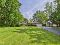 Beautiful home featuring a lush green lawn, mature trees, and well-maintained landscaping at 4733 E 100 S, Anderson, IN 46017