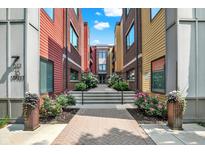 Inviting pathway leading to the building entrance, surrounded by colorful architecture and beautiful landscaping at 622 E 10Th St # 310, Indianapolis, IN 46202