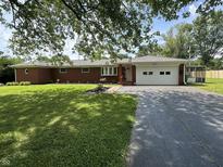 Charming brick ranch-style home with well-manicured lawn and attached garage at 6237 E Lynn Dr, Mooresville, IN 46158