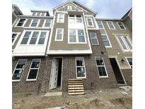 New construction of a brick and vinyl townhome exterior featuring white trim and many windows at 7313 Bayview Run, McCordsville, IN 46055