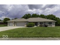 Charming single-story brick home featuring a well-maintained lawn and an attached two-car garage at 7741 Long Branch Dr, Indianapolis, IN 46259