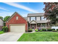 Charming two-story home features a brick facade, covered porch, well-maintained lawn and an attached two car garage at 8030 Parcrest Ct, Indianapolis, IN 46259