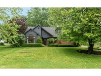 Charming exterior view of a well-maintained home with beautiful landscaping and mature trees at 8140 Springwater W Dr, Indianapolis, IN 46256