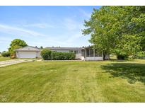 Exterior view of home with well-maintained lawn, detached garage, and screened-in porch at 1114 E 234Th St, Sheridan, IN 46069