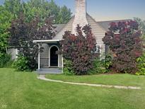 Charming home with a well-manicured lawn, mature trees, and inviting front porch at 1141 N Shadeland Ave, Indianapolis, IN 46219