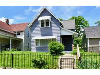 Charming two-story home featuring a well-maintained lawn and decorative awnings at 1346 W 27Th St, Indianapolis, IN 46208