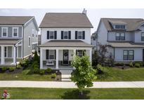 Charming two-story home with a welcoming front porch and manicured lawn and swing at 15557 Starflower Dr, Westfield, IN 46074