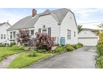 Charming two-story home featuring a landscaped front yard and a detached garage at 1621 Beeler Ave, Speedway, IN 46224