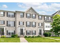 Charming brick townhome featuring manicured lawn, symmetrical design and inviting front entrances at 174 Straughn Ln, Westfield, IN 46074