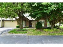 Charming brick home featuring mature trees, a two-car garage, and a well-maintained front yard at 1783 Cloister Dr, Indianapolis, IN 46260