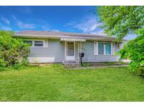 Charming single-story home with light-colored siding, well-manicured lawn, and inviting front entrance at 267 S Grant Ave, Indianapolis, IN 46201