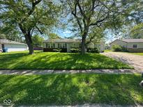 Ranch home with mature trees and lush, green grass in the front yard at 3155 Roseway Dr, Indianapolis, IN 46226