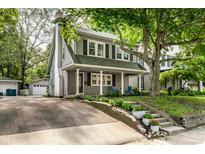 Charming two-story home featuring a welcoming front porch, well-manicured landscaping, and a detached garage at 4619 N Park Ave, Indianapolis, IN 46205
