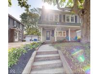 Charming two-story home featuring a welcoming front porch and landscaped garden leading to the front door at 4619 N Park Ave, Indianapolis, IN 46205