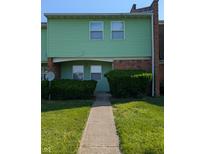 Charming two-story home with green siding, brick accents, and well-maintained landscaping at 6322 Commons Dr, Indianapolis, IN 46254