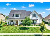 Beautiful two-story modern farmhouse featuring a manicured lawn and inviting front porch at 6882 Bladstone Rd, Noblesville, IN 46062