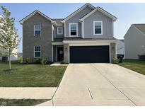 Charming two-story home featuring a gray brick and siding exterior, a black garage door, and a well-manicured lawn at 6883 Honeysuckle Way, Pendleton, IN 46064