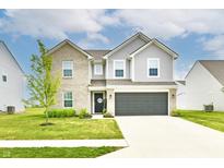 Charming two-story home featuring a brick and vinyl exterior, a well-manicured lawn, and an attached two-car garage at 6883 Honeysuckle Way, Pendleton, IN 46064