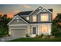 Charming two-story home featuring a two-car garage, manicured lawn, and classic architectural details at sunset at 7177 Firestone Rd, Whitestown, IN 46052